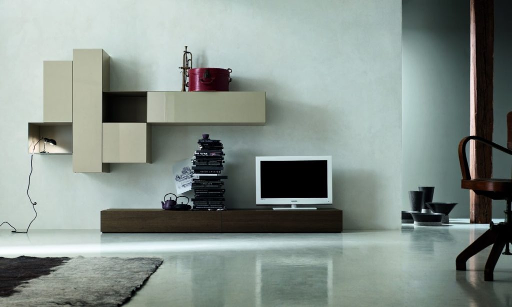Soggiorno moderno con porta TV in legno e pensili con inserti in metallo laccato.